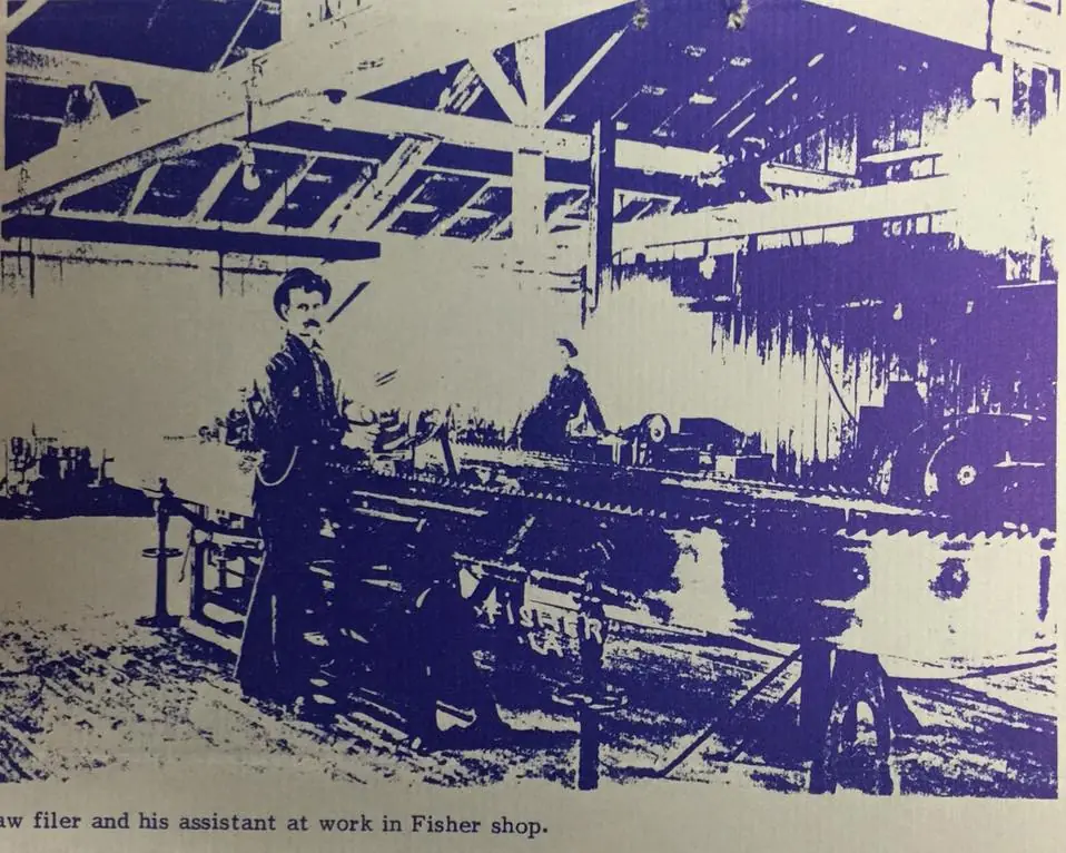 Photograph from the Facebook post “Saw filer and his assistant hard at work at the Fisher mill.”