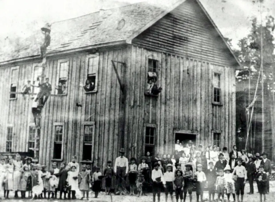 Photograph from the Facebook post “Children and adults posed at the first school in DeRidder.”