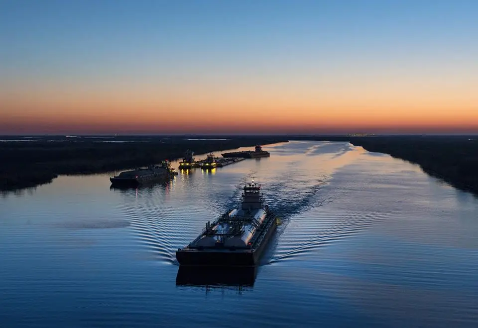 Photograph from the Facebook post “Dusk shot of barges traversing a short canal that connects the Sabine Pass waterway…”