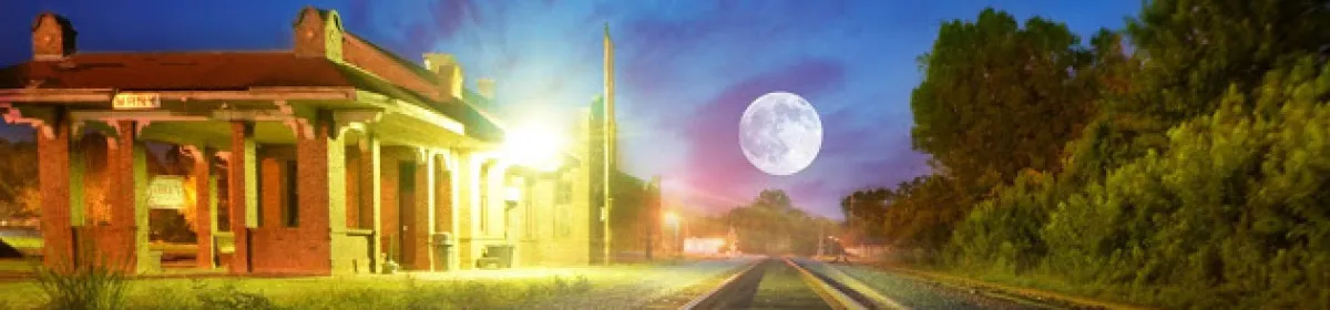 The depot and railroad tracks in Many, Louisiana, under a moonlit sky